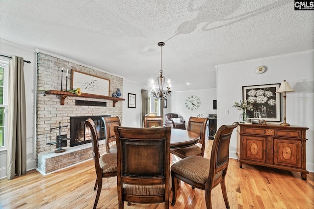 164 Carriageton Dr, Orangeburg, SC 29115 - dining area with light wood finished floors, a brick fireplace, a textured ceiling, and crown molding