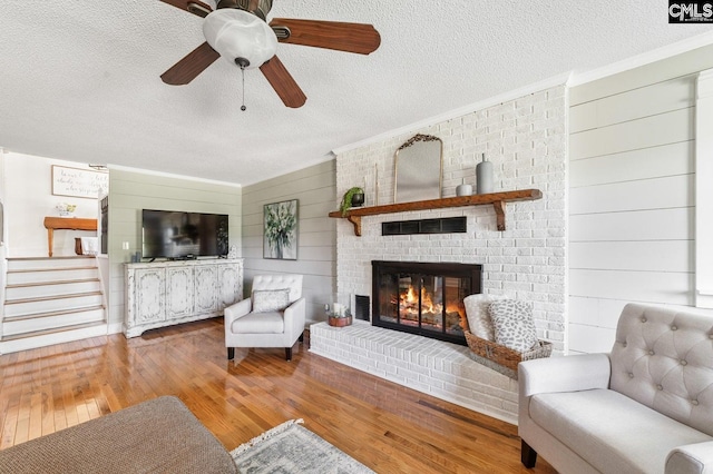 164 Carriageton Dr, Orangeburg, SC 29115 - living area with a ceiling fan, stairs, wood-type flooring, a textured ceiling, and a brick fireplace