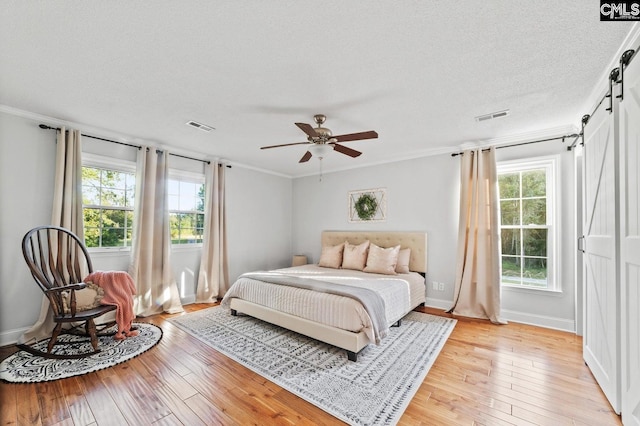 164 Carriageton Dr, Orangeburg, SC 29115 - bedroom with a barn door, visible vents, and light wood-style floors