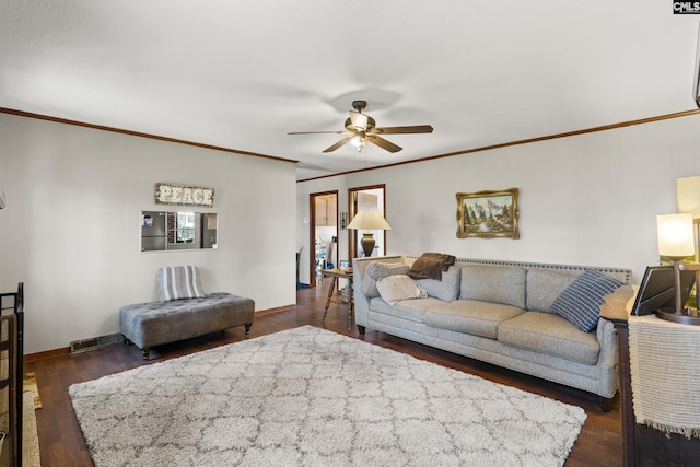 living area featuring baseboards, dark wood finished floors, a ceiling fan, and ornamental molding