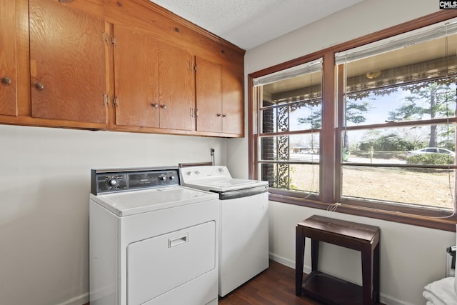 laundry area featuring washing machine and clothes dryer, cabinet space, baseboards, and dark wood-style flooring