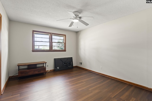 spare room featuring visible vents, dark wood-type flooring, a textured ceiling, baseboards, and ceiling fan