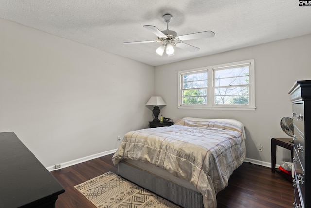 bedroom with a textured ceiling, a ceiling fan, baseboards, and wood finished floors