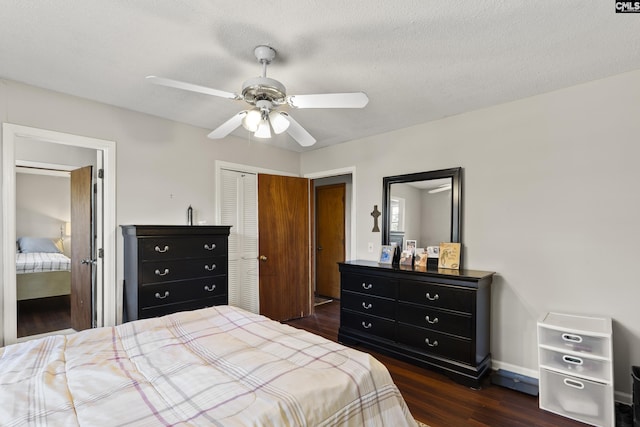 bedroom with baseboards, dark wood-style floors, a closet, a textured ceiling, and a ceiling fan