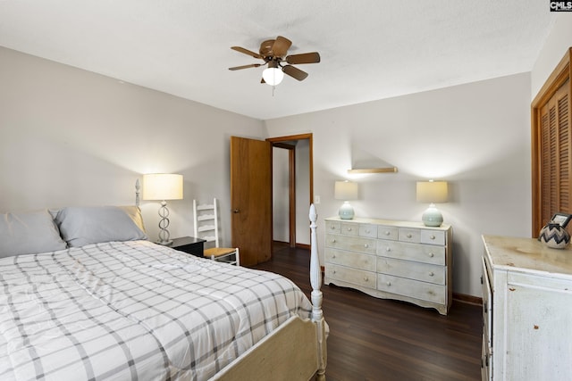 bedroom featuring a closet, baseboards, dark wood-type flooring, and a ceiling fan