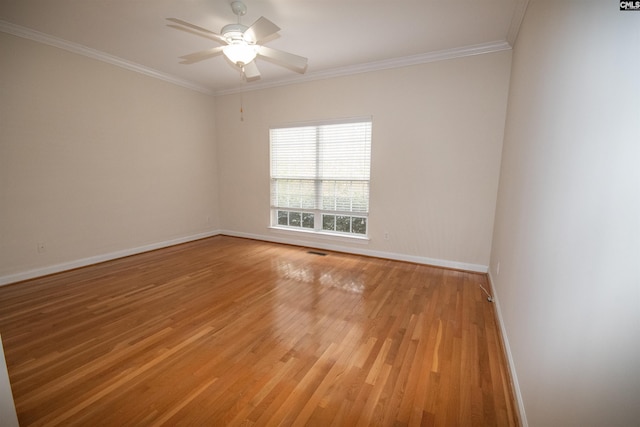 spare room featuring baseboards, ornamental molding, a ceiling fan, and light wood finished floors