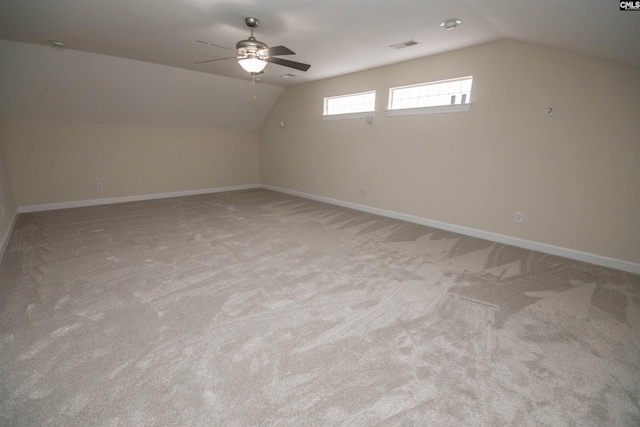 bonus room with lofted ceiling, a ceiling fan, baseboards, and light carpet