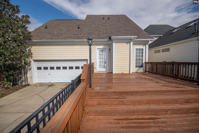 deck featuring an attached garage and driveway