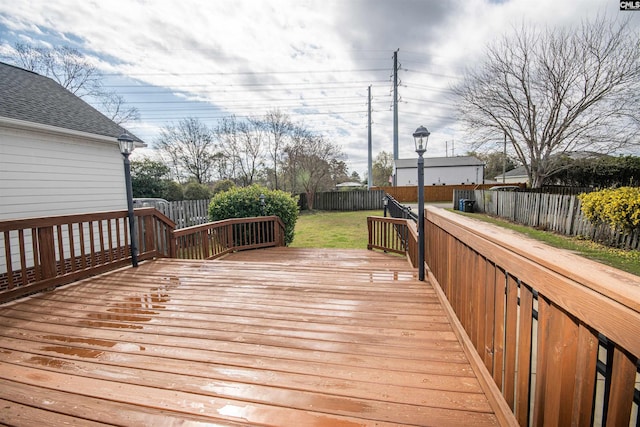 wooden terrace with a yard and a fenced backyard