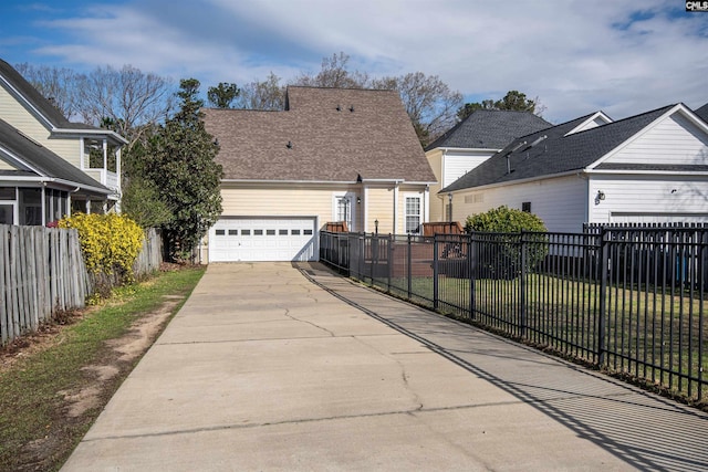 view of home's exterior featuring a yard, fence, a garage, and driveway