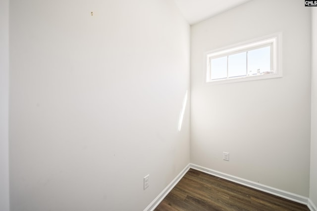 empty room featuring baseboards and dark wood-style flooring