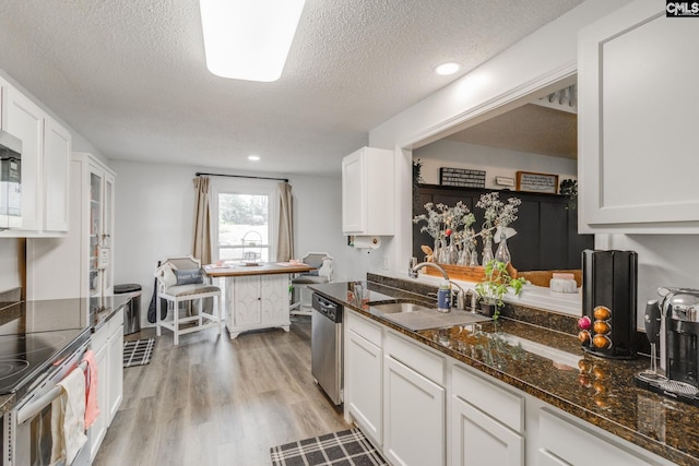 kitchen featuring white cabinetry, a sink, light wood-type flooring, and stainless steel appliances