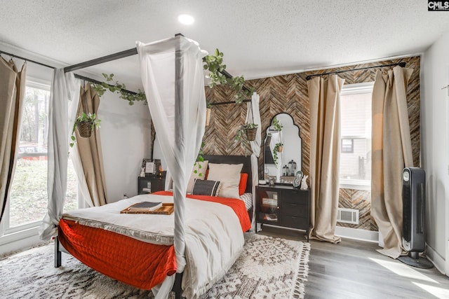bedroom with a textured ceiling and wood finished floors