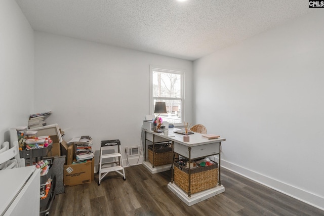 office area featuring visible vents, a textured ceiling, baseboards, and wood finished floors