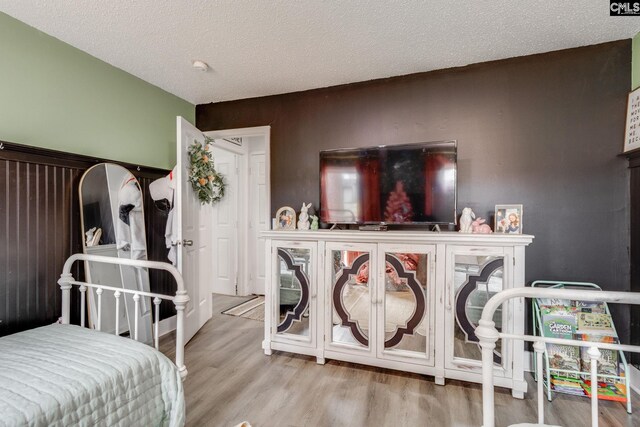 bedroom with wood finished floors and a textured ceiling