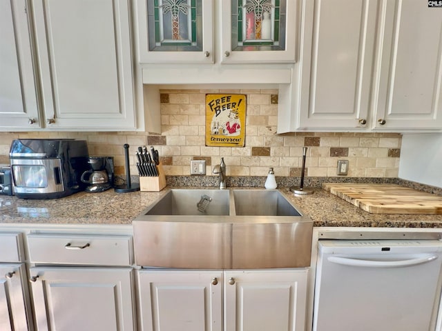 541 Georgia St, Columbia, SC 29201 - kitchen with a sink, backsplash, white cabinets, white dishwasher, and glass insert cabinets