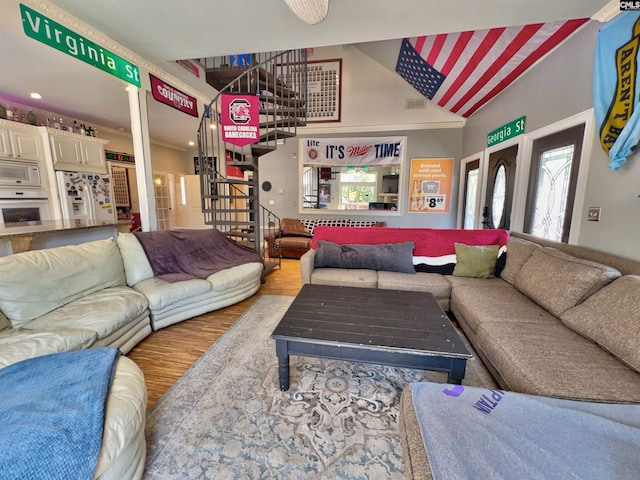 541 Georgia St, Columbia, SC 29201 - living area with stairway, wood finished floors, visible vents, high vaulted ceiling, and decorative columns