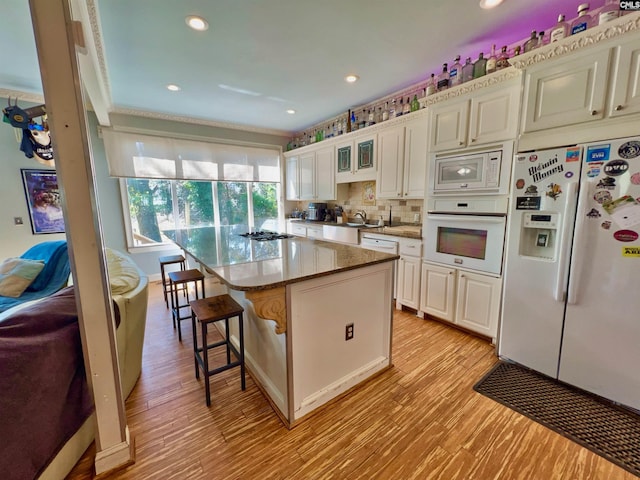 541 Georgia St, Columbia, SC 29201 - kitchen featuring a kitchen breakfast bar, white appliances, light wood-style floors, and decorative backsplash