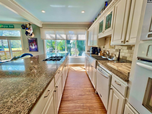 541 Georgia St, Columbia, SC 29201 - kitchen featuring gas cooktop, wood finish floors, a sink, decorative backsplash, and dishwasher