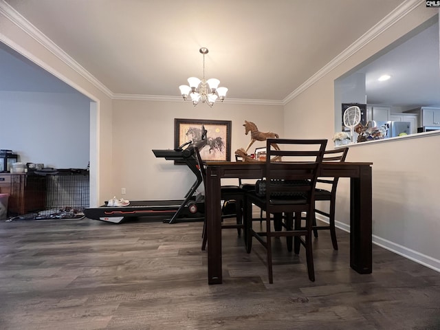dining room featuring ornamental molding, wood finished floors, baseboards, and a chandelier