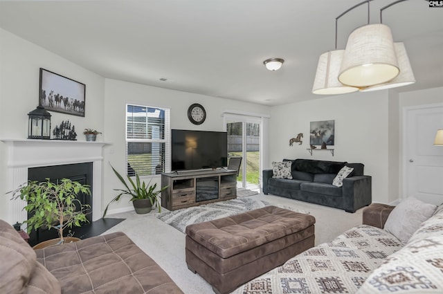 living room featuring a wealth of natural light, carpet flooring, baseboards, and a fireplace with flush hearth