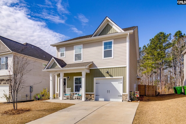 view of front facade featuring a porch, an attached garage, concrete driveway, stone siding, and board and batten siding