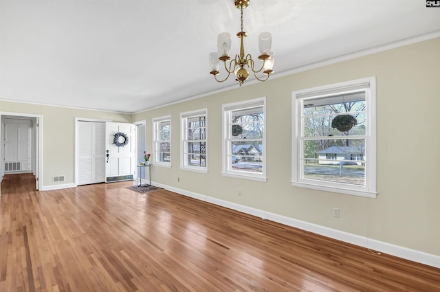1632 Romain Dr, Columbia, SC 29210 - unfurnished living room featuring a notable chandelier, a healthy amount of sunlight, baseboards, and visible vents
