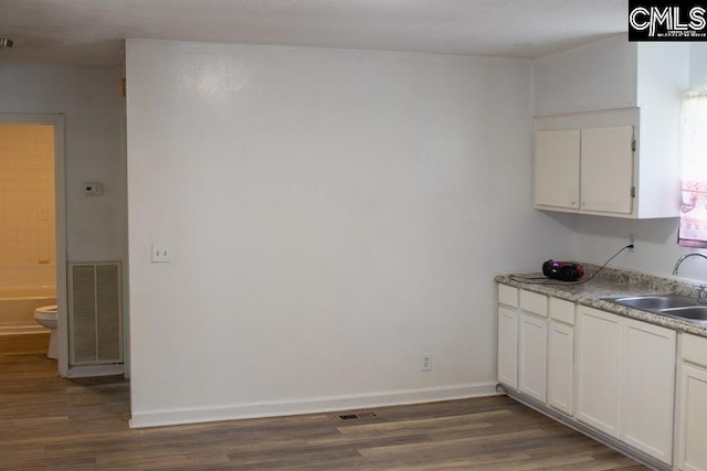 212/210 Nash Rd, Bishopville, SC 29010 - kitchen with dark wood finished floors, visible vents, white cabinetry, and a sink