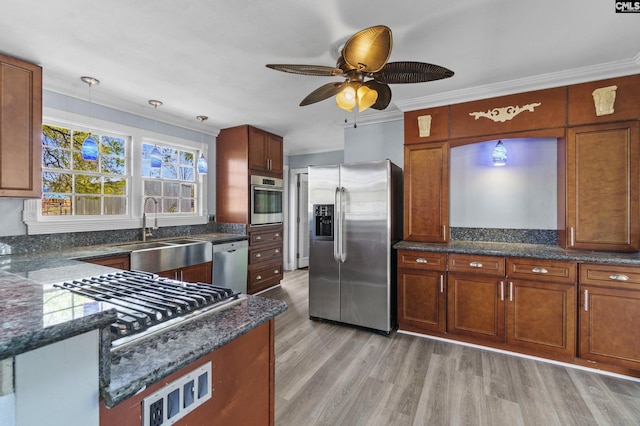 kitchen featuring crown molding, light wood-style flooring, a sink, a ceiling fan, and appliances with stainless steel finishes