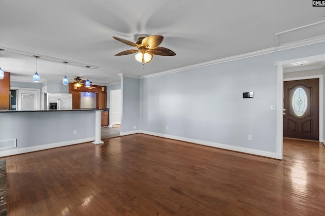 unfurnished living room featuring crown molding, baseboards, dark wood finished floors, ceiling fan, and visible vents