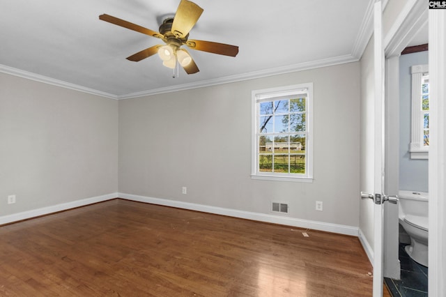 spare room featuring plenty of natural light, baseboards, visible vents, and wood finished floors