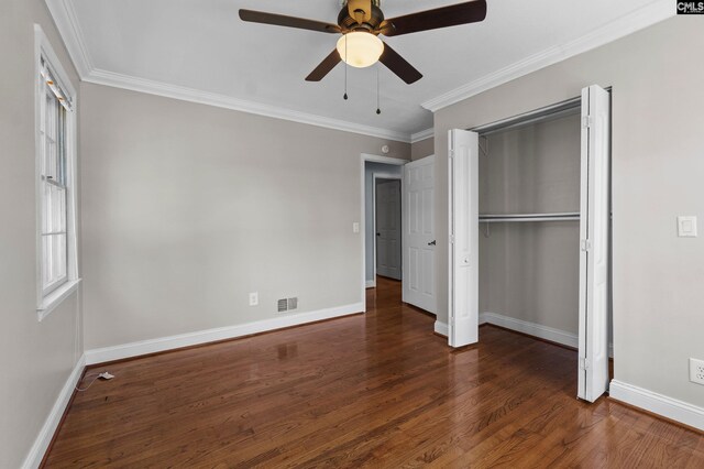 unfurnished bedroom featuring wood finished floors, crown molding, baseboards, and visible vents