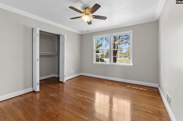 unfurnished bedroom with baseboards, wood finished floors, and ornamental molding