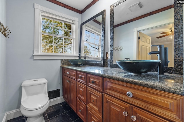 bathroom with toilet, a sink, ornamental molding, and visible vents