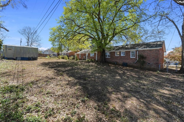 view of yard featuring an outbuilding and fence
