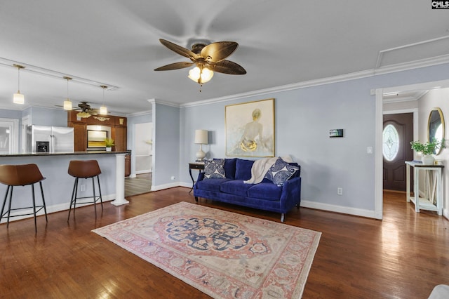living area with dark wood-type flooring, crown molding, and ceiling fan