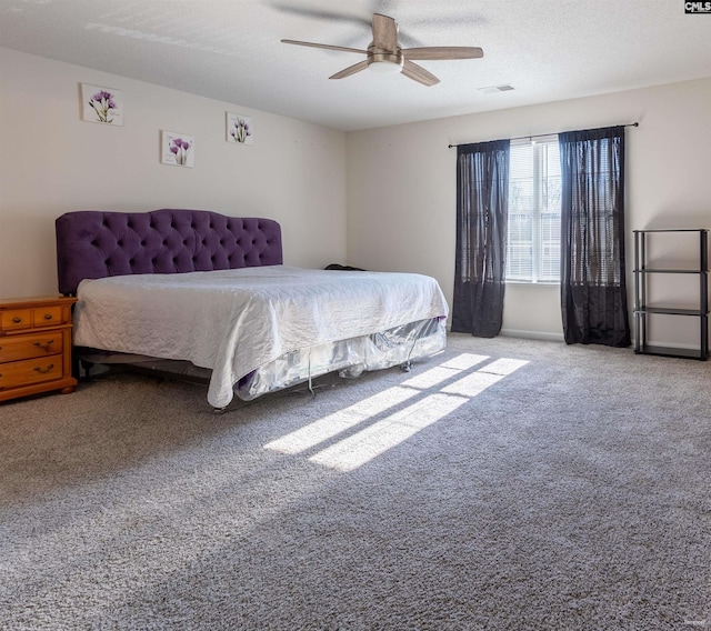 bedroom with carpet flooring, a textured ceiling, visible vents, and a ceiling fan