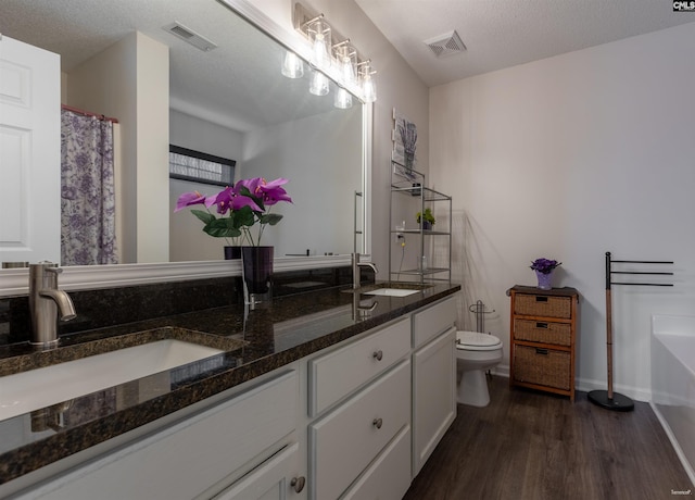 bathroom with a sink, visible vents, and toilet