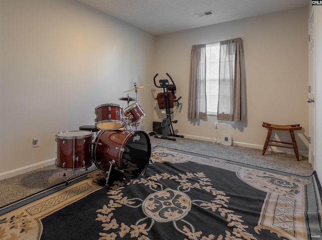 workout room featuring baseboards, visible vents, and carpet flooring