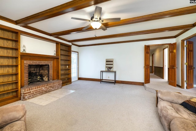 unfurnished living room with beam ceiling, a brick fireplace, baseboards, ceiling fan, and ornamental molding