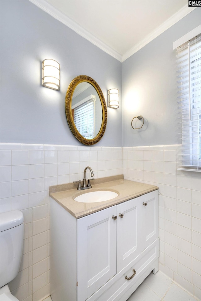 half bath featuring a wainscoted wall, toilet, ornamental molding, and tile walls