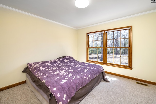 bedroom featuring carpet floors, ornamental molding, baseboards, and visible vents