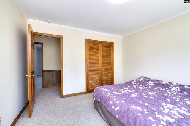 bedroom with a closet, carpet flooring, baseboards, and crown molding