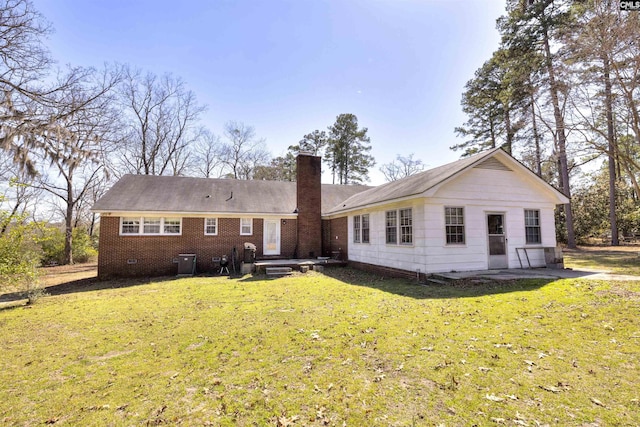 back of property featuring a chimney, crawl space, a patio area, and a lawn