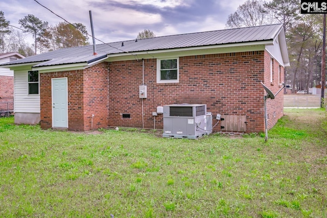 4104 Candlelite Dr, Columbia, SC 29209 - rear view of house with central AC unit, a lawn, metal roof, and brick siding