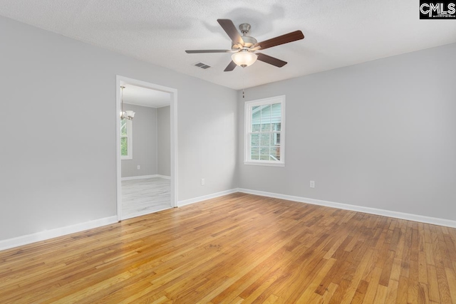 4104 Candlelite Dr, Columbia, SC 29209 - spare room featuring ceiling fan with notable chandelier, visible vents, light wood-type flooring, and plenty of natural light