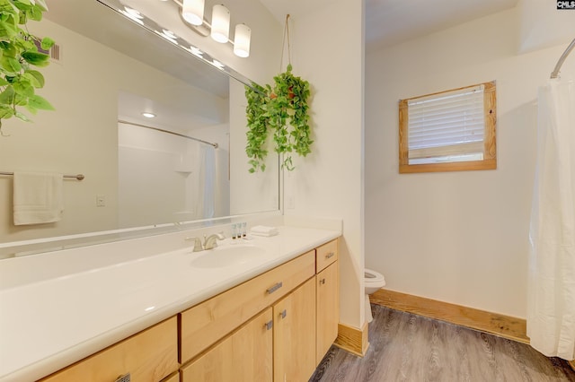 full bath featuring baseboards, wood finished floors, toilet, and curtained shower