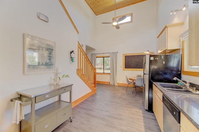 kitchen with ceiling fan, a sink, stainless steel appliances, and light wood-type flooring