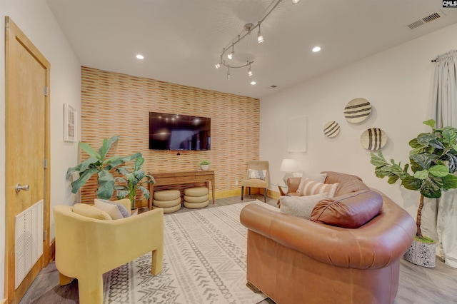 living area with visible vents, wallpapered walls, recessed lighting, and an accent wall