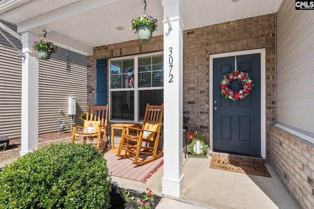 doorway to property with stone siding and a porch